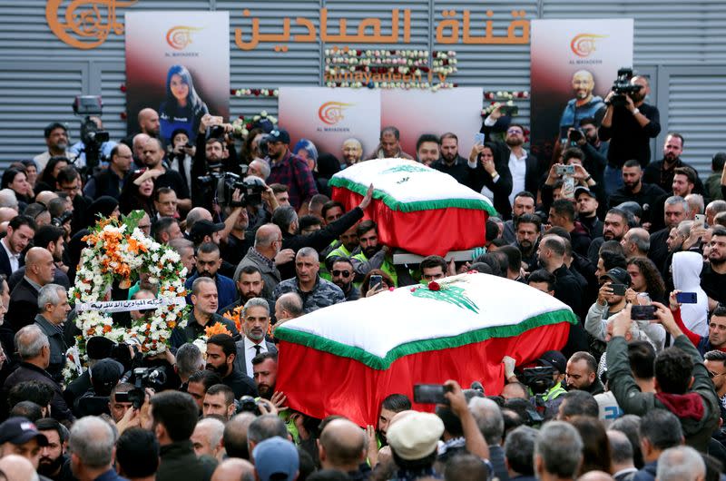 Mourners stand near the coffins of the two journalists working for Lebanon-based Al Mayadeen TV channel, in Beirut