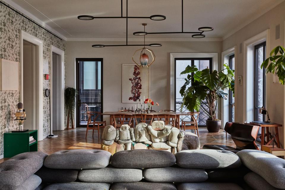 The dining area is outfitted with a Hans Wegner dining table and chairs, a photographic work by Adam Fuss, candlesticks by Ted Muehling, and a Bec Brittain pendant lamp from Matter.