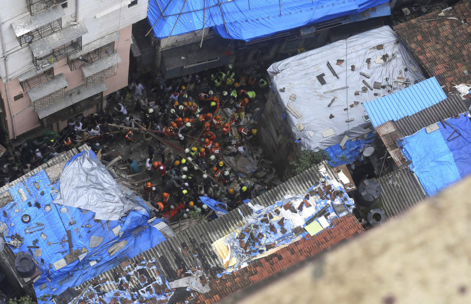 Rescuers work at the site of a building that collapsed in Mumbai, India, Tuesday, July 16, 2019. A four-story residential building collapsed Tuesday in a crowded neighborhood in Mumbai, India's financial and entertainment capital, and several people were feared trapped in the rubble, an official said. (AP Photo/Rajanish Kakade)