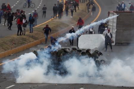 Personas chocan con soldados mientras bloquean una carretera durante las protestas después de que el gobierno del presidente de Ecuador, Lenin Moreno, terminó con los subsidios a los combustibles, en Lasso, Ecuador.