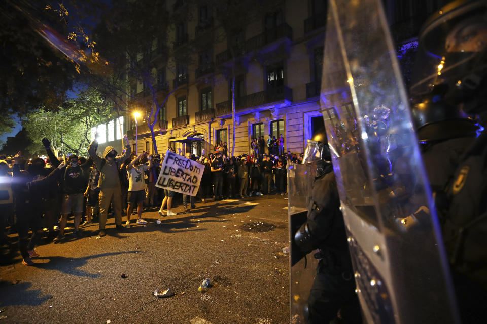 Protestors face a line of riot police outside the Spanish Government Office in Barcelona, Spain, Tuesday, Oct. 15, 2019. Spain's Supreme Court on Monday convicted 12 former Catalan politicians and activists for their roles in a secession bid in 2017, a ruling that immediately inflamed independence supporters in the wealthy northeastern region. (AP Photo/Emilio Morenatti)