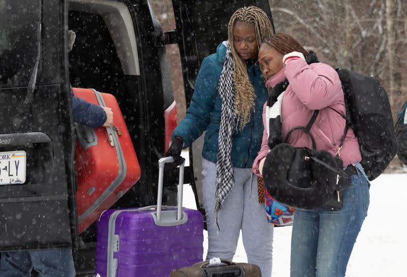 Asylum seekers cross into Canada from Roxham Road in Champlain New York