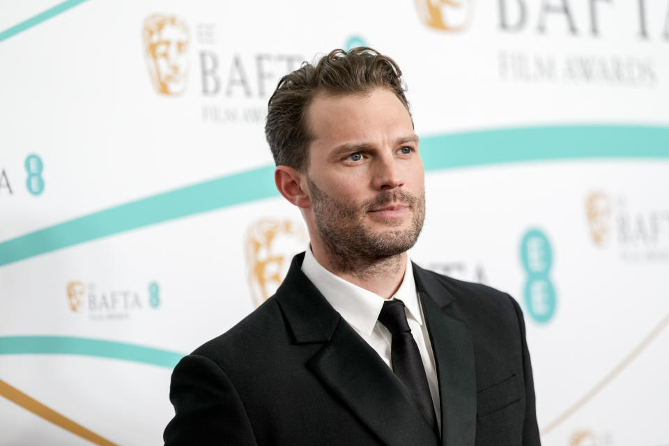 Jamie Dornan in a black suit and tie at the BAFTA Film Awards red carpet event