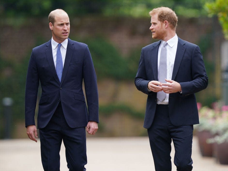 Prince William and Prince Harry wearing suits.