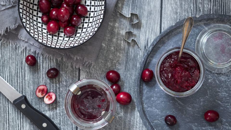 preserving glasses of cranberry jam and fresh cranberries