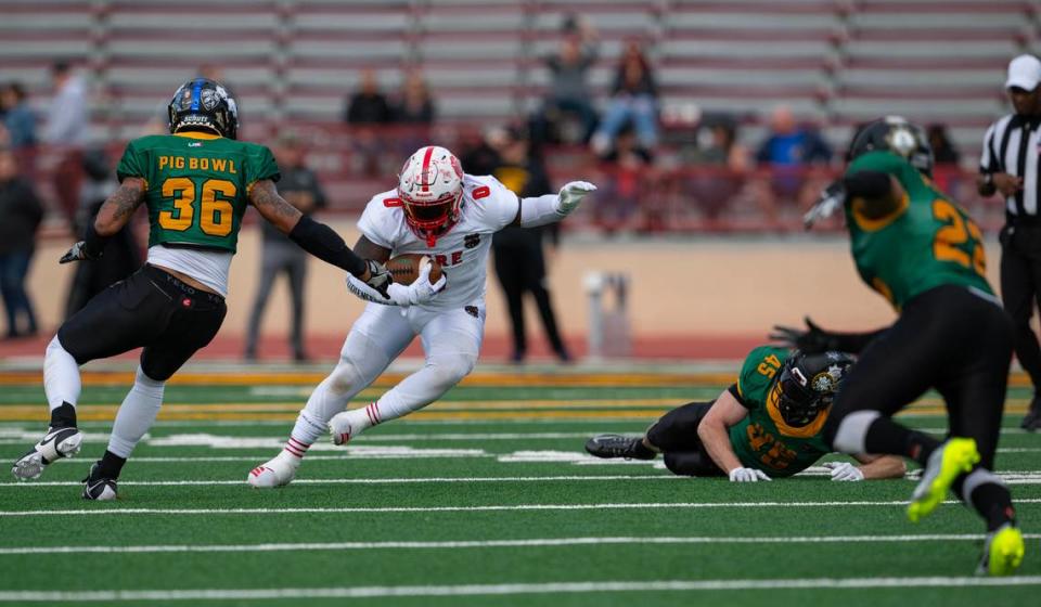 Fire Dogs running back Komi Tay rushes for a short gain against the Law Hogs in the 50th Pig Bowl on Saturday at Hughes Stadium. Nathaniel Levine/nlevine@sacbee.com