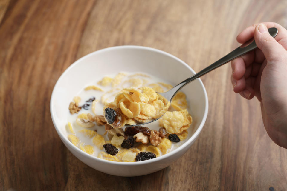 someone scooping cereal out of a bowl with a spoon