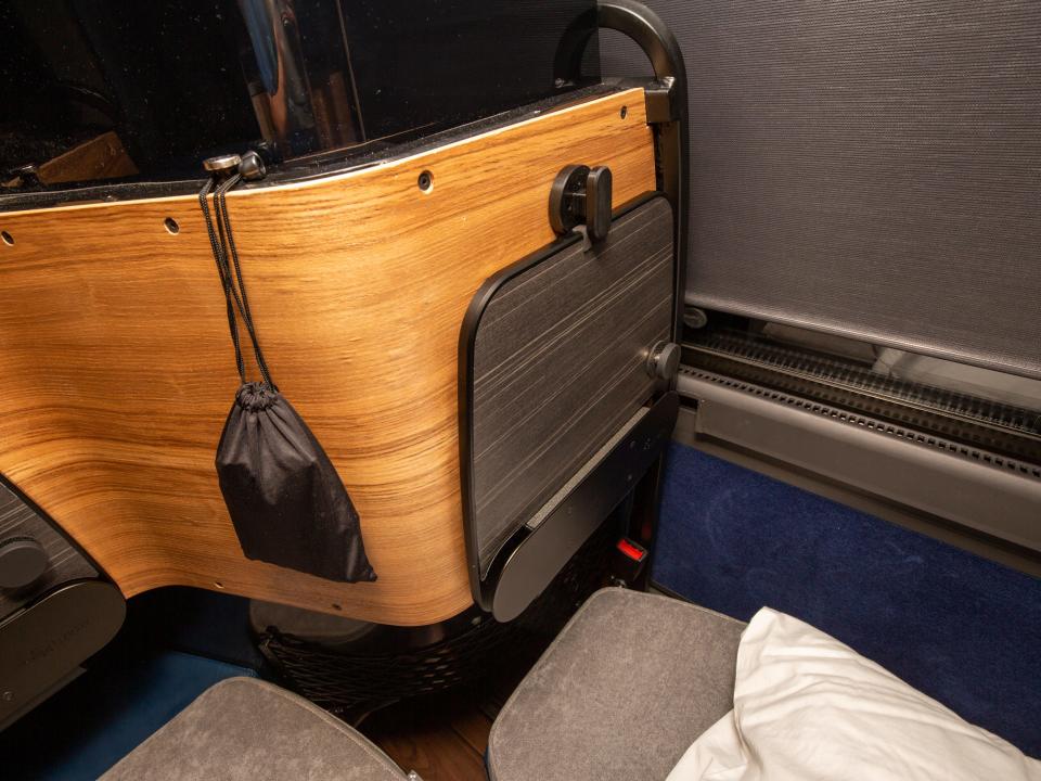 A tray table on a wall that divides the seats.