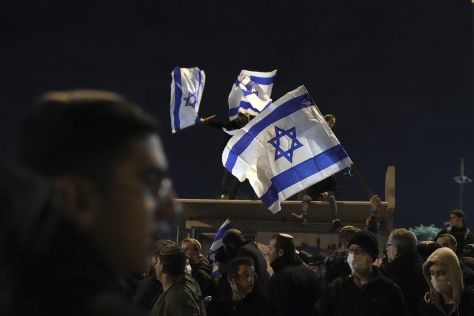 Israeli nationalists protest outside the parliament building in Jerusalem, calling on the government not to demolish a West Bank settlement outpost, Thursday, Jan. 13, 2022. (AP Photo/Ariel Schalit)