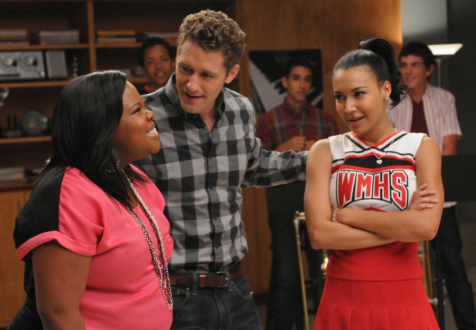 Will (Matthew Morrison, C) assigns Mercedes (Amber Riley, L) and Santana (Naya Rivera, R) a duet in the "Duets" episode of "Glee."