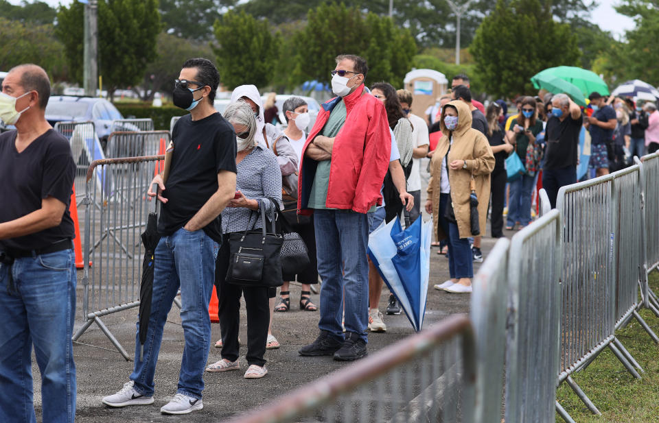 People stand in line to receive a COVID-19 vaccine