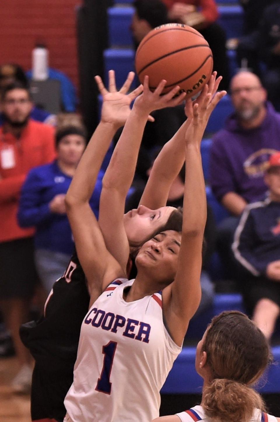 Cooper's Jaedah Titus (1) battles Lubbock Coronado's Jazlyn Braithwaite for a rebound.