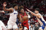 Houston Rockets' Jalen Green, center, drives to the basket as Washington Wizards' Vernon Carey Jr. (13) and Deni Avdija (9) defend during the first half of an NBA basketball game Wednesday, Jan. 25, 2023, in Houston. (AP Photo/David J. Phillip)