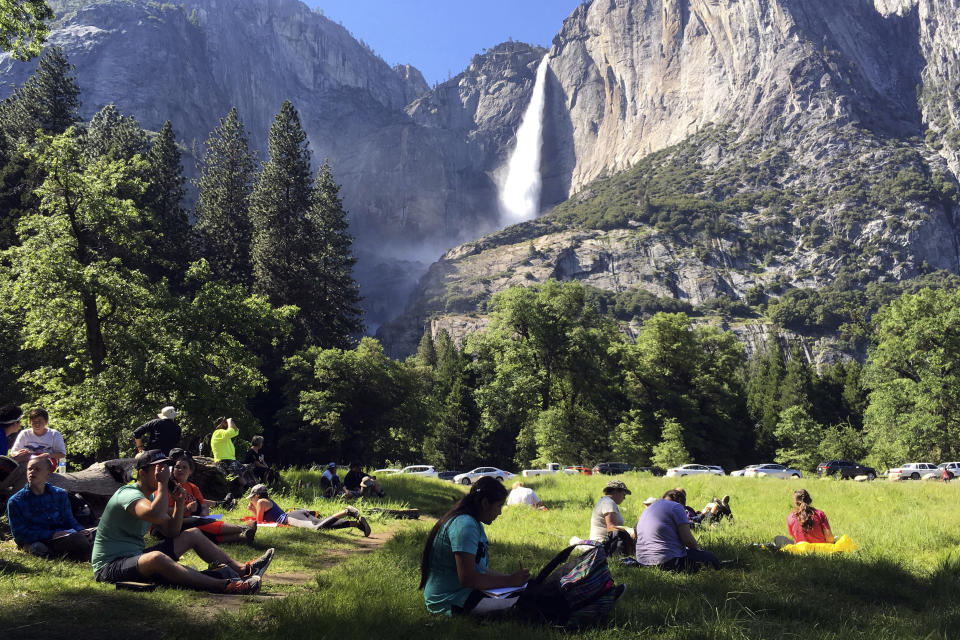 FILE - In this May 25, 2017 file photo, a class of eighth-grade students and their chaperones sit in a meadow at Yosemite National Park, Calif., below Yosemite Falls. Interior Secretary David Bernhardt announced the surprise replacement Friday, Aug. 7, 2020, of the 30-year parks veteran running the National Park Service, naming one of his advisers, Margaret Everson, to run the agency instead as it begins to help divvy up a new, multibillion-dollar annual bequest from Congress. (AP Photo/Scott Smith, File)