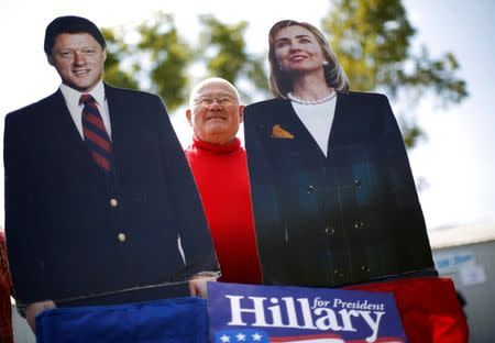 Supporter Dick Furinash holds up cardboard cut-outs of former U.S. Secretary of State Hillary Clinton (R) and her husband former U.S. President Bill Clinton at the 37th Harkin Steak Fry in Indianola, Iowa, September 14, 2014. REUTERS/Jim Young