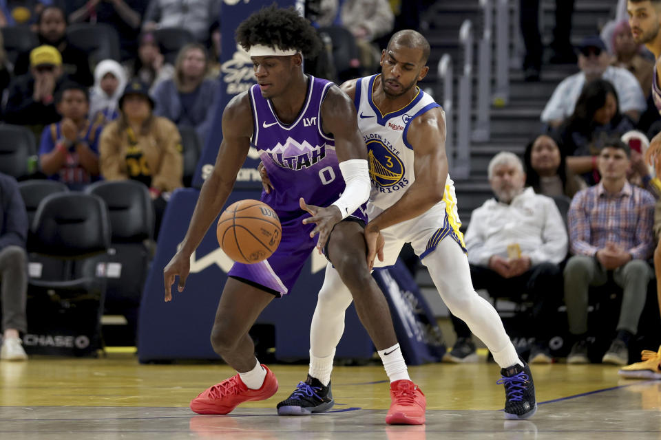 Utah Jazz forward Taylor Hendricks (0) is defended by Golden State Warriors guard Chris Paul (3) during the first half of an NBA basketball game in San Francisco, Sunday, April 14, 2024. (AP Photo/Jed Jacobsohn)