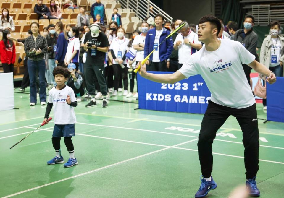 東奧羽球雙打金牌王齊麟、李洋（左）八日出席小小英雄運動會，跟小朋友一起打羽球。（中央社）