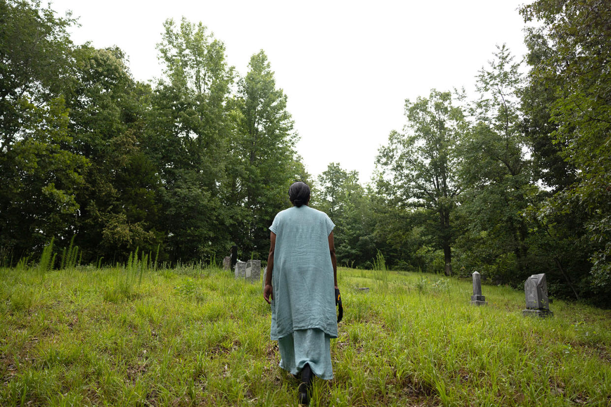 Lacretia Johnson Flash walks near tombstones on land that has been in her family for generations in Perry County, Linden, Tenn., on July 19, 2023. (Kevin Wurm / Reuters file)