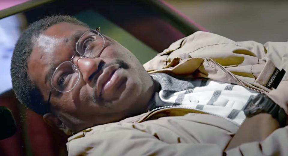 Lil Rel lying on the hood of his car