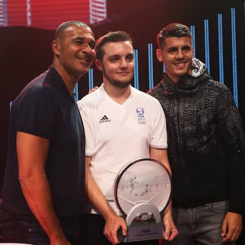 Spencer 'Gorilla' Ealing (centre) presented with the winners trophy at last year's Fifa eWorld Cup by Ruud Gullit (left) and Alvaro Morata - Spencer 'Gorilla' Ealing (centre) presented with the winners trophy at last year's Fifa eWorld Cup by Ruud Gullit (left) and Alvaro Morata - Credit: Getty Images