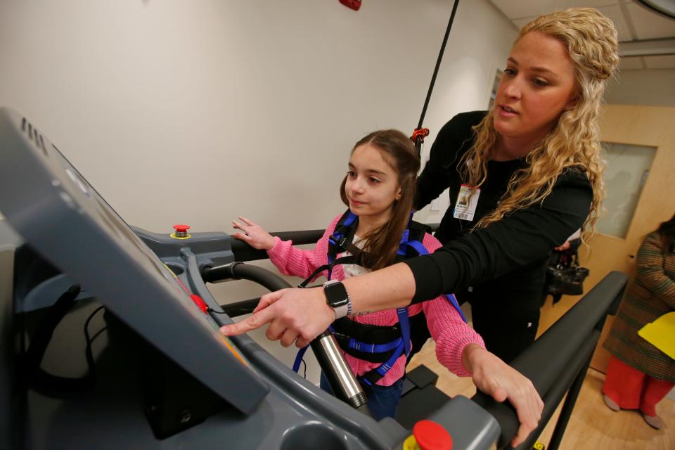 Physical therapist, Rebecca Cameron, starts the treadmill for Arianna Krowel, 10, to walk on with the assistance of a suspension system installed at the new Southcoast Health Pediatric Rehabilitation Program building on Acushnet Avenue in New Bedford.