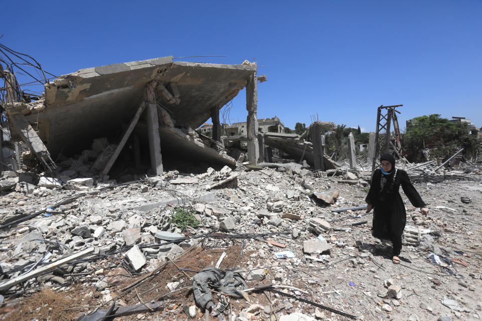 Eine Frau geht an einem zerstörten Gebäude im libanesischen Aita al-Shaab vorbei (Bild: AFP)