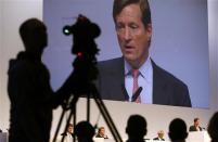 CEO Brady Dougan (R) of Swiss bank Credit Suisse is seen on a huge TV screen as he addresses the annual shareholder meeting in Zurich in this April 26, 2013 file photo. REUTERS/Arnd Wiegmann/Files