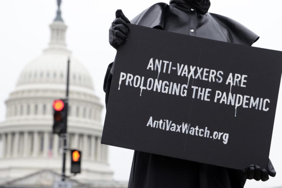 A man holds a sign and dresses as a plague doctor to encourage people to be vaccinated and help prevent prolonging the COVID-19 pandemic March 25, 2021 on Capitol Hill in Washington, DC. (Photo by Alex Wong/Getty Images)