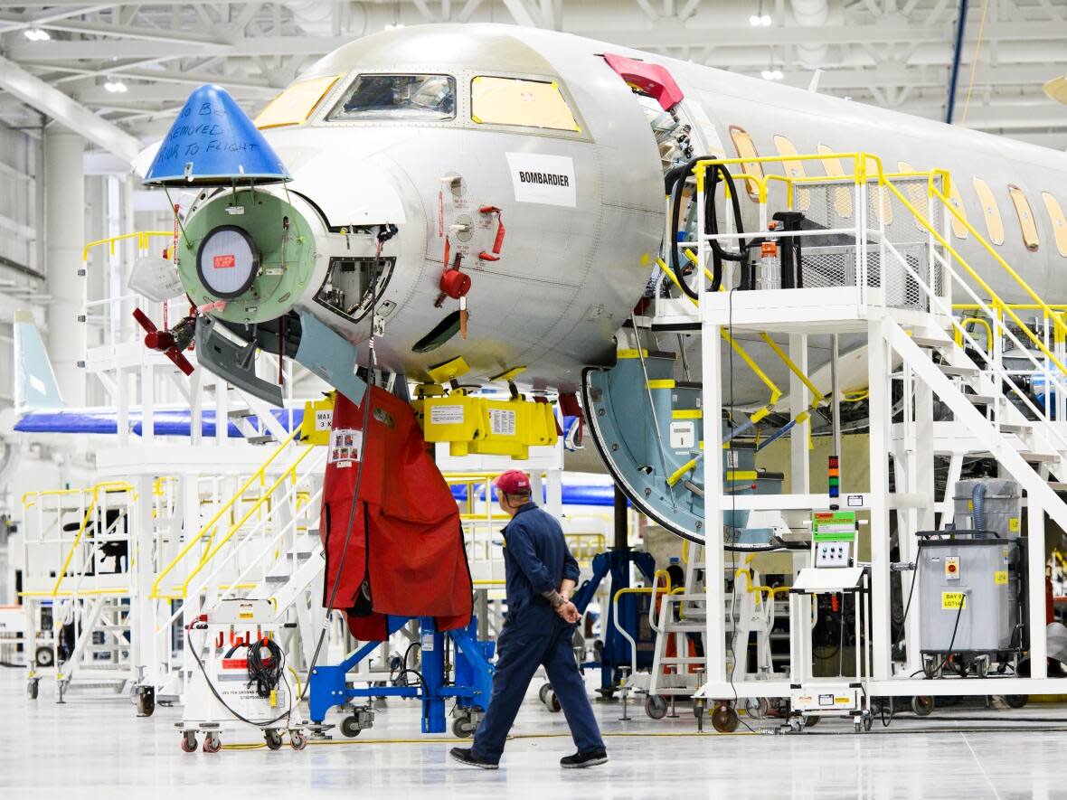 Employees work on aircraft during a media preview of the Bombardier Aircraft Assembly Centre in Mississauga, Ont. on Monday, Jan. 22, 2024. (Christopher Katsarov/The Canadian Press - image credit)