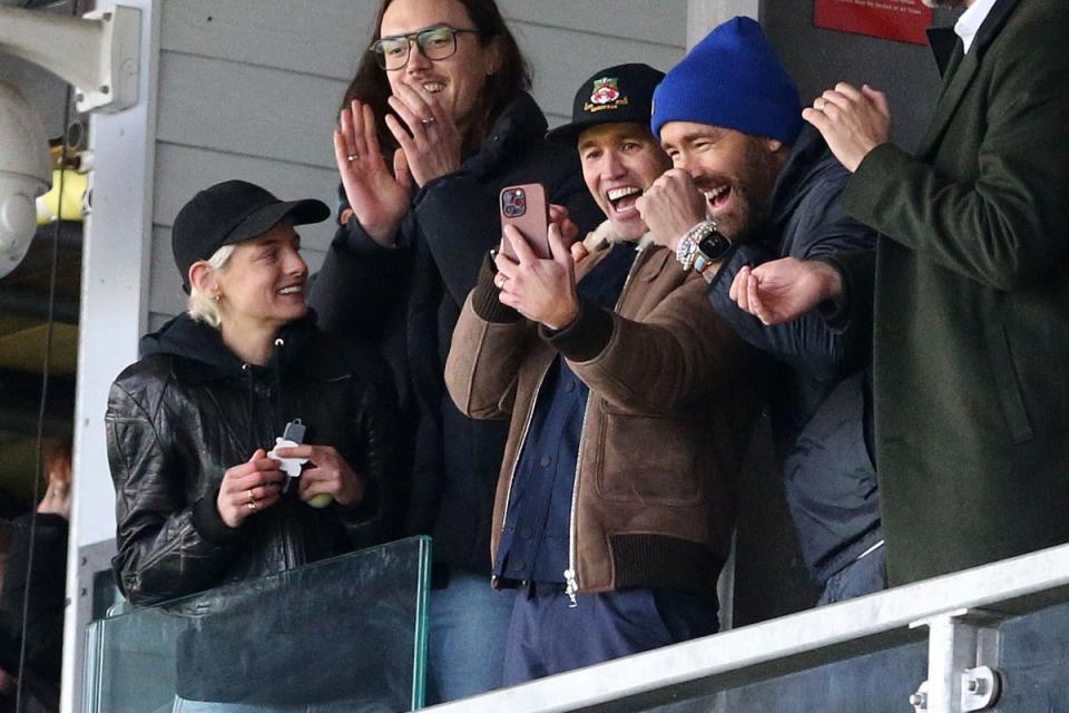 Wrexham owners Ryan Reynolds and Rob McElhenney celebrate alongside Emma Corrin (PA)