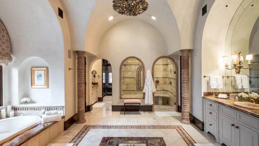 The first-floor master bathroom comes complete with a onyx/marble-clad bath overlooking the grounds.