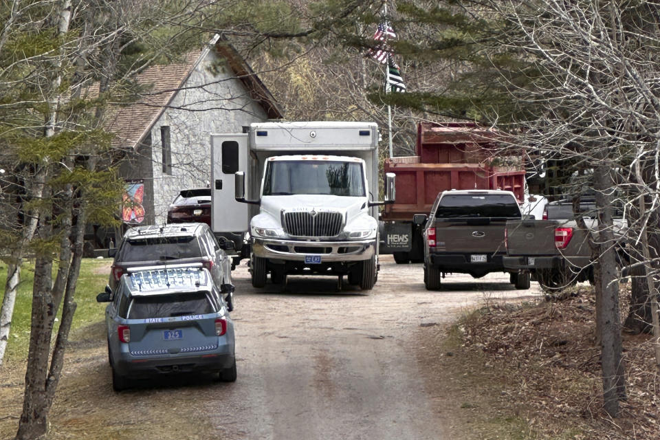 Law enforcement and other vehicles are parked at a at a crime scene in Bowdoin, Maine, Wednesday, April 19, 2023. A Maine man who police say killed four people in a home and then shot three others randomly on a busy highway Tuesday had been released days earlier from prison, a state official said Wednesday. (AP Photo/Rodrique Ngowi)
