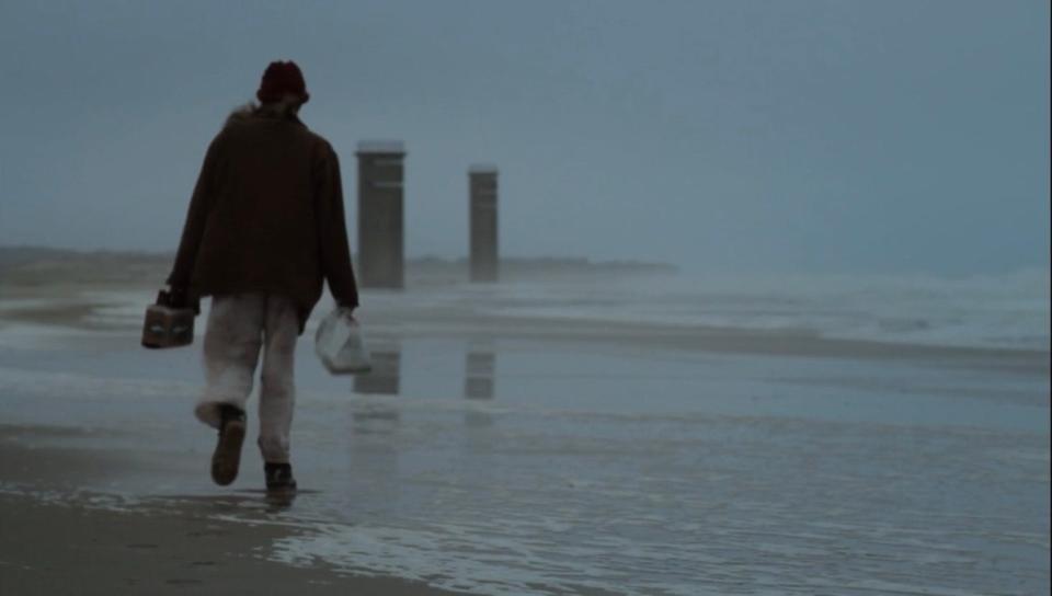 Greta Gerwig walks along the coast at Delaware's beaches with World War II watchtowers looming in the distance from the 2011 film "The Dish & the Spoon."