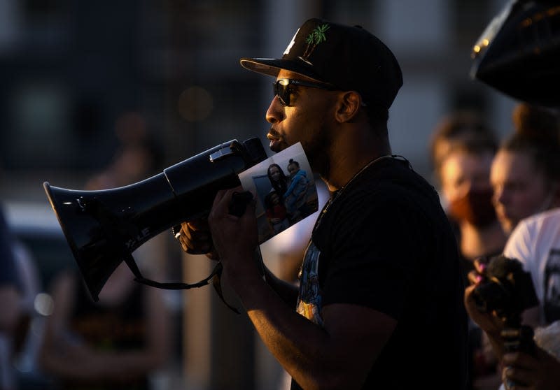 MINNEAPOLIS, MN - JUNE 04: Tommy McBrayer holds a photo of Winston Boogie Smith and his children during a vigil on June 4, 2021 in Minneapolis, Minnesota.