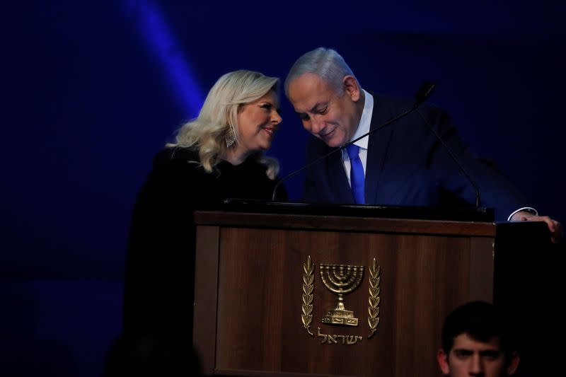 Israeli Prime Minister Benjamin Netanyahu listens to his wife Sara during his address to supporters following the announcement of exit polls in Israel's election at his Likud party headquarters in Tel Aviv