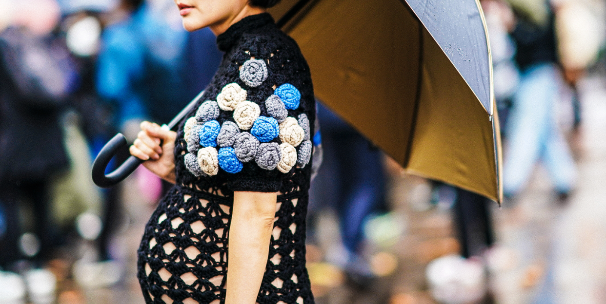pregnant woman holding an umbrella and wearing a crochet dress