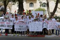 Palestinian children hold up red cards during a protest held upon the arrival of FIFA president Sepp Blatter to his hotel in Jerusalem May 19, 2015. On top of land, settlements, resources and borders, Israel and the Palestinians can add another dispute to their long history of conflict - football. FIFA President Sepp Blatter has spoken to the head Palestine Football Association Jibril Rajoub and Ofer Eini, chairman of the Israel Football Association, and is visiting the region this week in the hope of finding a solution before May 29. REUTERS/Ammar Awad