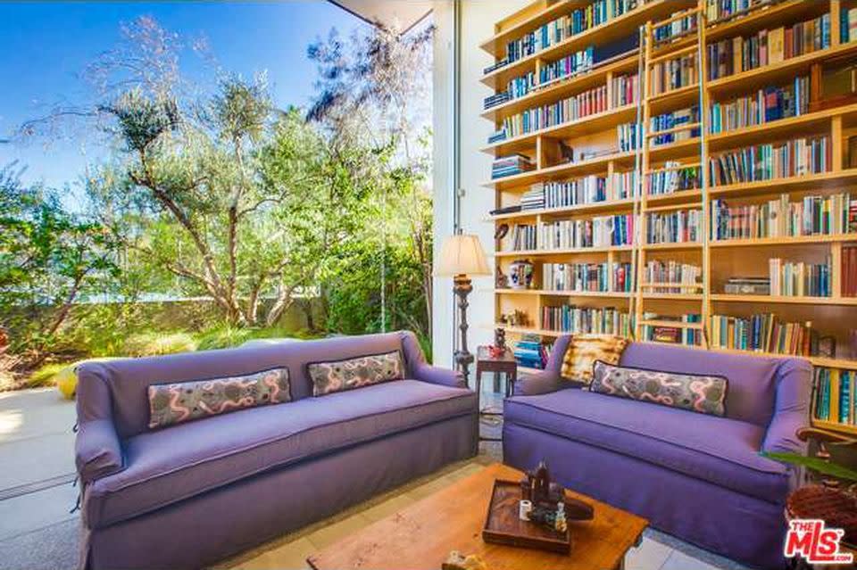 <p>The open-concept living room is centered around an enormous custom wood bookcase, which we can only assume will be used to store her copies of George R.R. Martin’s “Song of Ice and Fire.” (Zillow) </p>