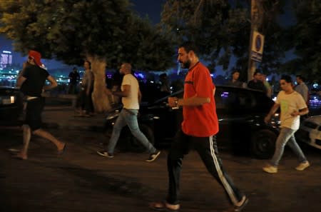 Small groups of protesters shout anti-government slogans and run from tear gas fired by riot police near Tahrir Square in Cairo