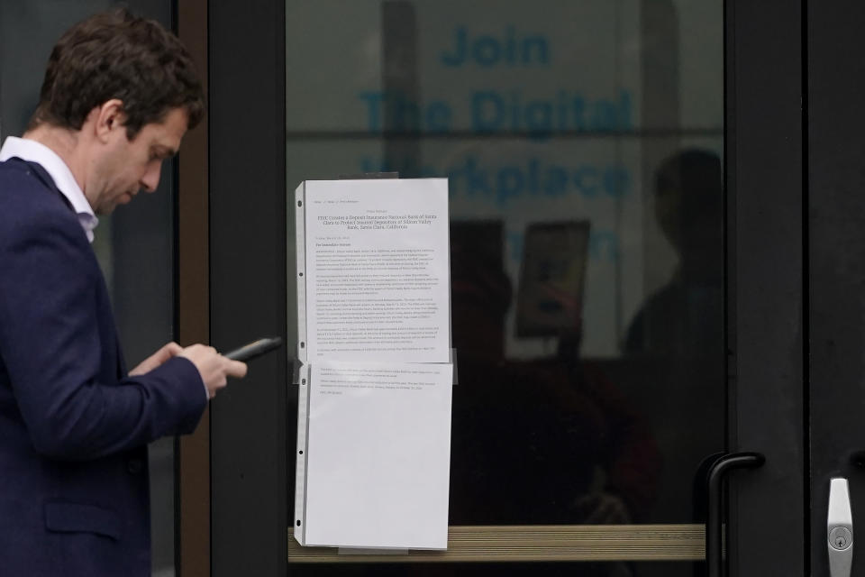 A person walks past a sign posted at an entrance to Silicon Valley Bank in Santa Clara, Calif., Friday, March 10, 2023. The Federal Deposit Insurance Corporation is seizing the assets of Silicon Valley Bank, marking the largest bank failure since Washington Mutual during the height of the 2008 financial crisis. The FDIC ordered the closure of Silicon Valley Bank and immediately took position of all deposits at the bank Friday. (AP Photo/Jeff Chiu)