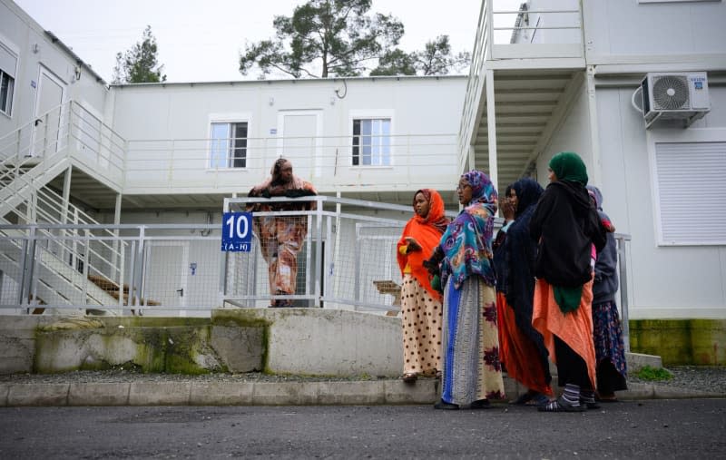 Refugees stand in front of containers at the Kofinou Reception and Accommodation Center for Applicants for International Protection in the municipality of Kofinou. Bernd von Jutrczenka/dpa