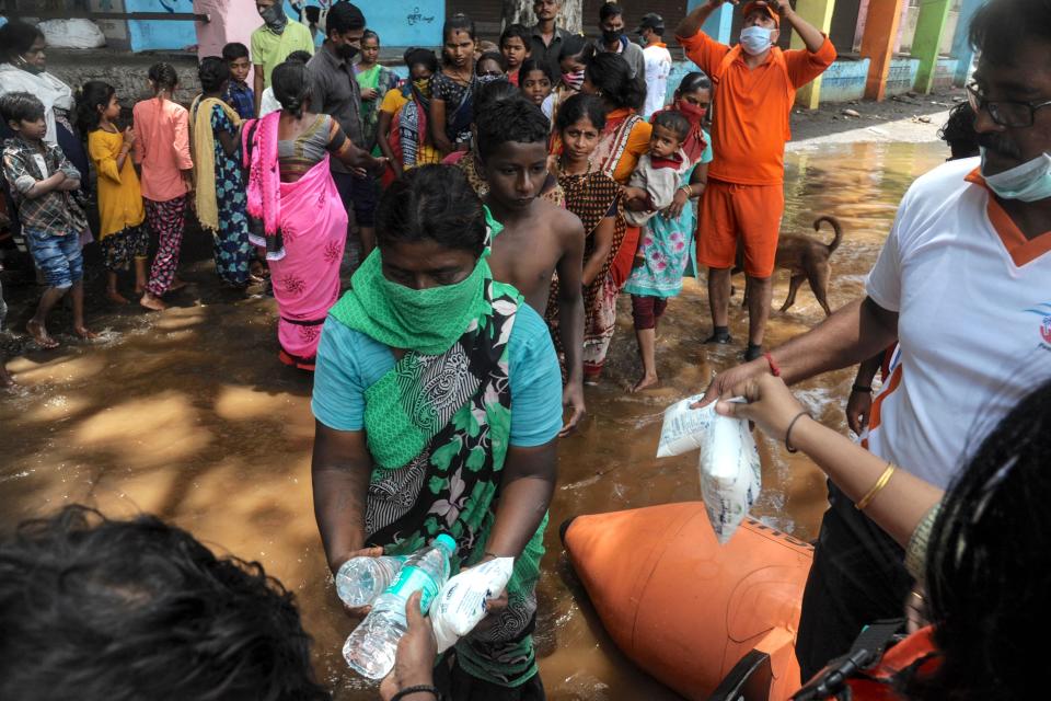 India's National Disaster Response Force (NDRF) personnel distribute food and relief material to people impacted by floods in Maharashtra  (Getty Images)