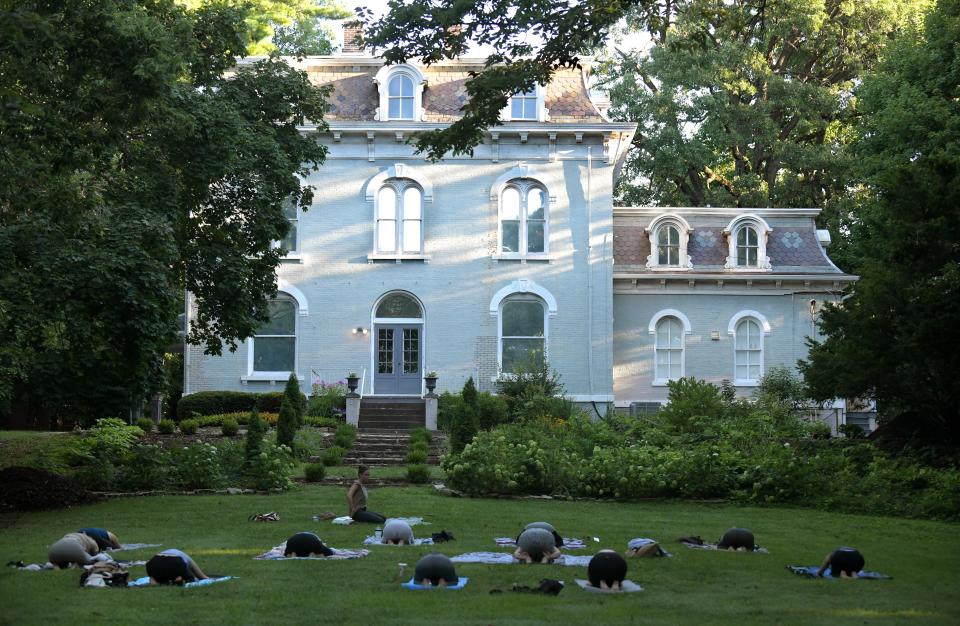 Students in Soulside Healing Arts sunrise yoga class practice outside the PettenGill-Morron House on Peoria's historic Moss Avenue on Thursday morning.