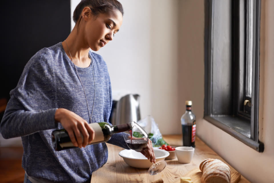 A young woman pouring some red wine