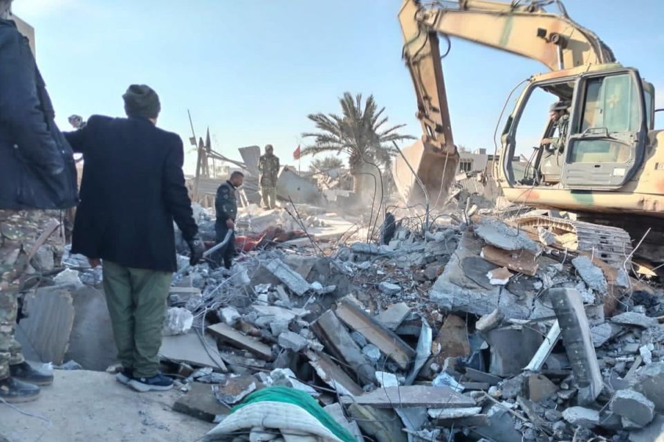 Members of Iraqi Shiite Popular Mobilization Forces clean the rubble after a US airstrike in al-Qaim on February 3 2024 (AP)