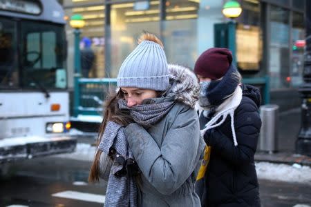 A woman bundles up against the cold temperature as she walks in Manhattan in New York City, New York, U.S., January 5, 2018. REUTERS/Amr Alfiky