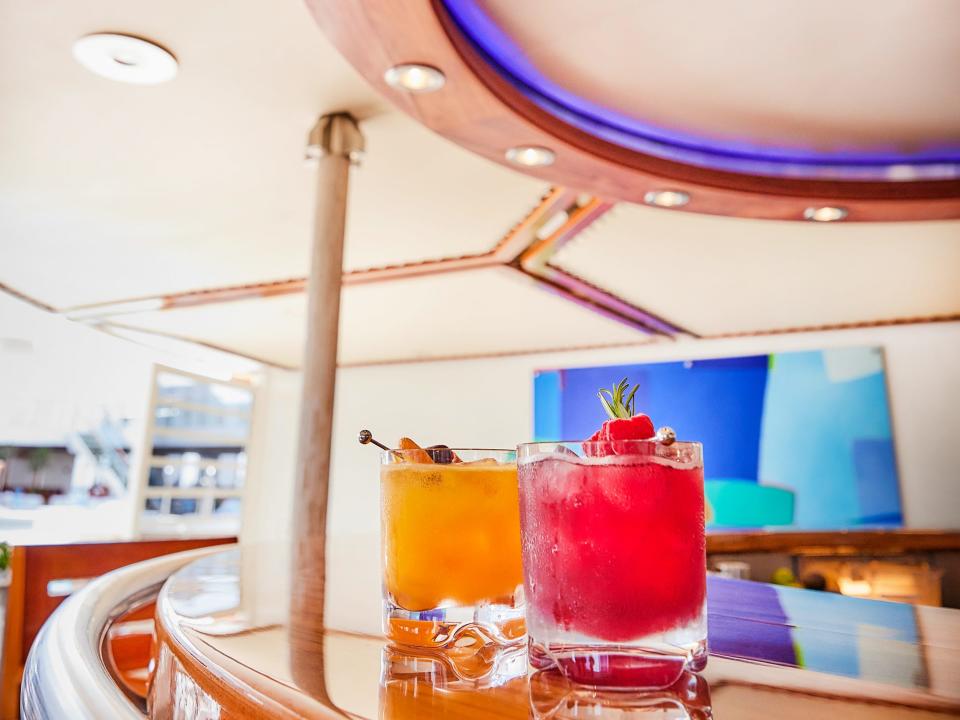 Two brightly-coloured cocktails on a bar inside The World.