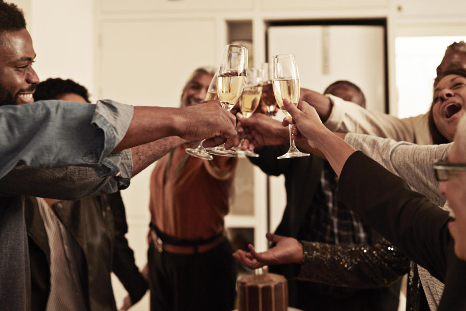 Cheerful male and female toasting champagne flutes during birthday celebration at home