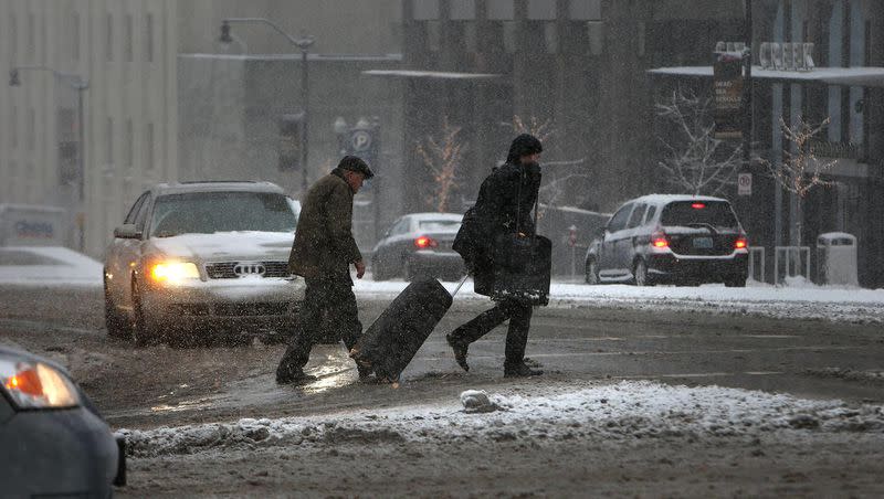 Pedestrians brave the icy and snowy streets in Salt Lake City on Thursday, Dec. 19, 2013.