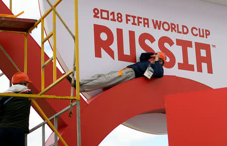 Workers rest while they put their final touches to a booth in Kazan Arena, ahead of the start of the World Cup Russia 2018 in Kazan, Russia June 14, 2018. REUTERS/Toru Hanai